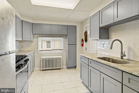 a kitchen with granite countertop a sink stove and cabinets