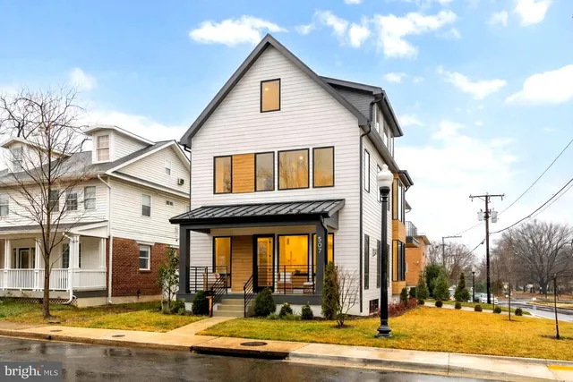 a large white kitchen with a large window and stainless steel appliances
