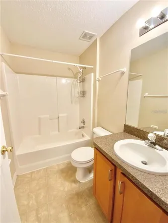 a bathroom with a granite countertop sink toilet a mirror and shower
