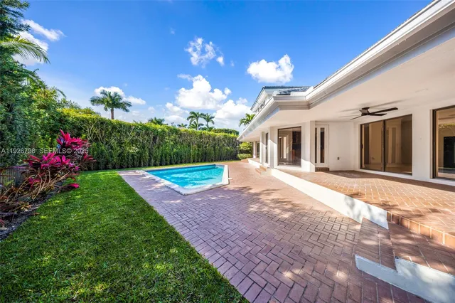 a view of an empty room with wooden floor and windows