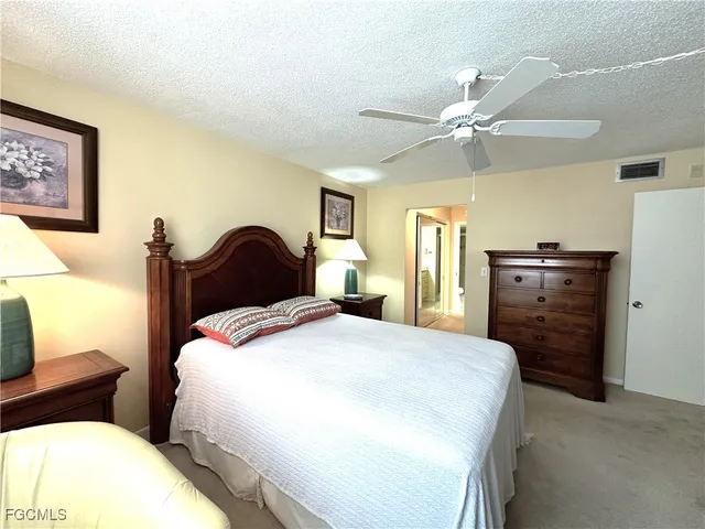 a bedroom with a bed and dresser with mirror