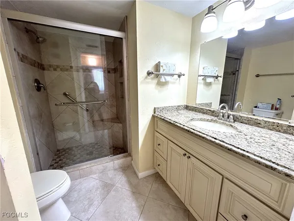 a bathroom with a granite countertop sink toilet and shower