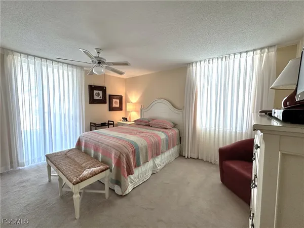 a bedroom with a bed and a flat tv screen on dresser