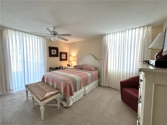 a bedroom with a bed and a flat tv screen on dresser