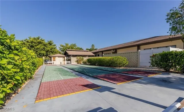 a view of a swimming pool with a yard and palm trees