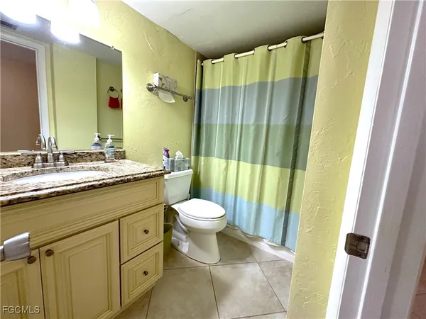 a bathroom with a double vanity sink toilet and shower