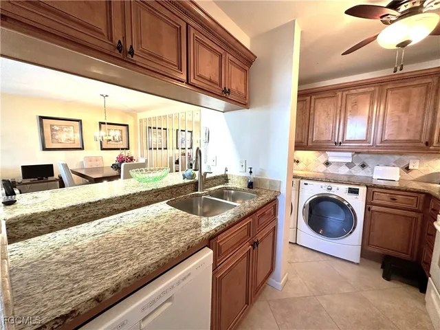 a kitchen with granite countertop a sink a stove and cabinets