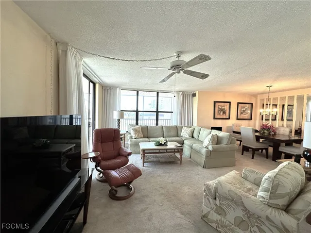a living room with furniture ceiling fan and a window