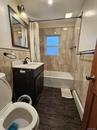 a bathroom with a sink a toilet a tub and shower