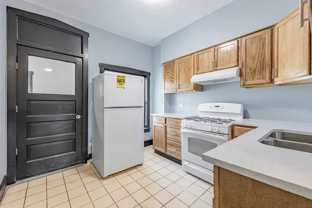 a kitchen with a refrigerator sink and cabinets