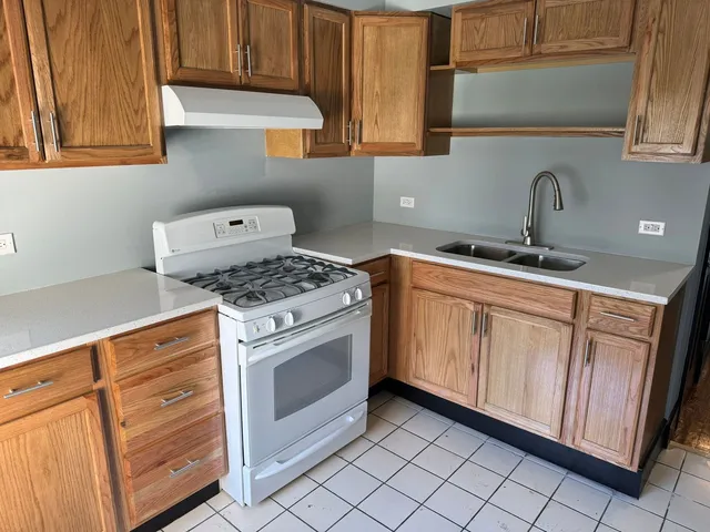 a kitchen with stainless steel appliances granite countertop a sink stove and cabinets