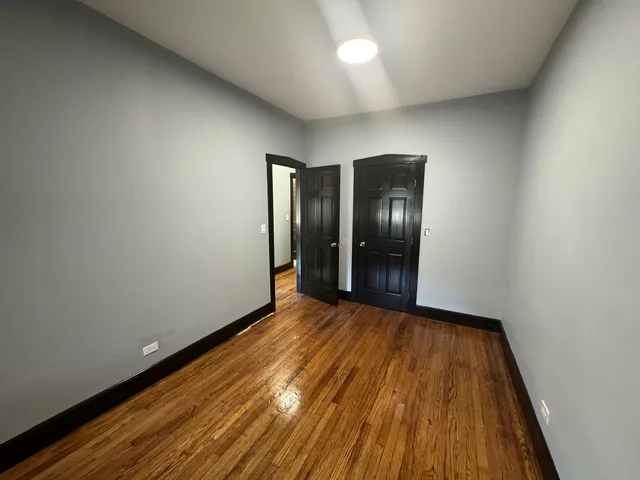 an empty room with wooden floor and natural light