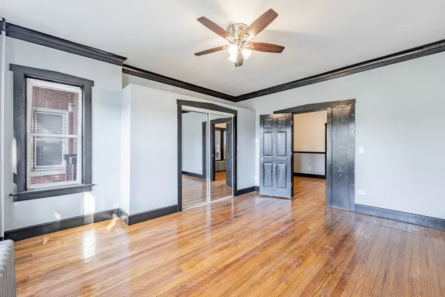 a view of an empty room with window and wooden floor