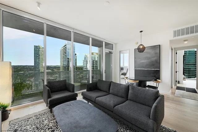 a living room with furniture and a floor to ceiling window