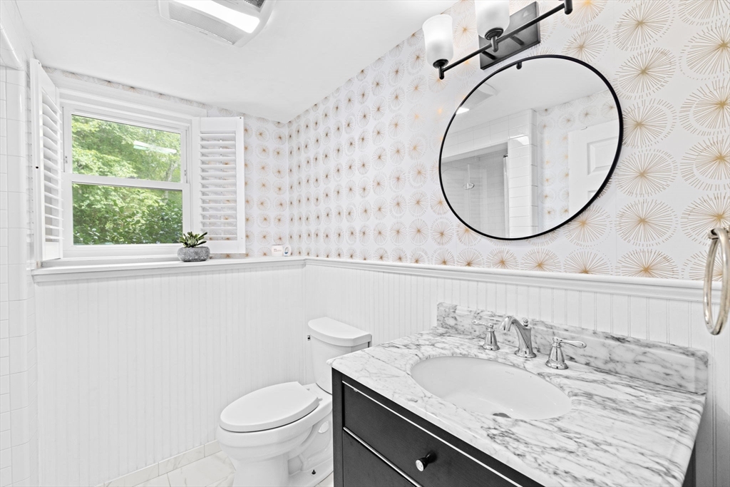 40 Brewster Road Cohasset, MA 02025 - Photo 33 of 42 a bathroom with a granite countertop toilet a sink and a mirror