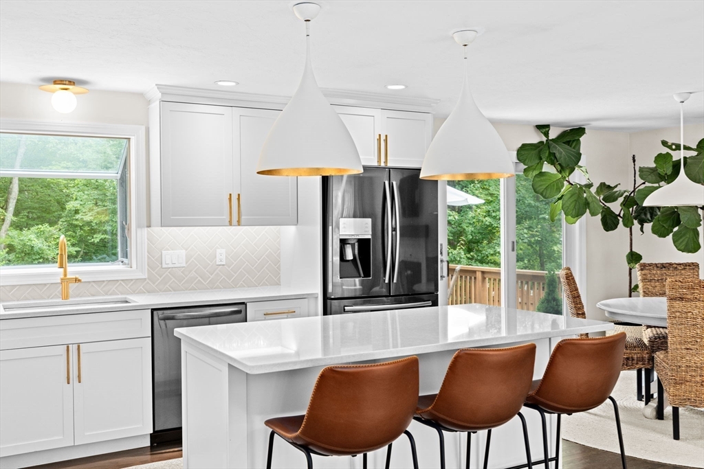 40 Brewster Road Cohasset, MA 02025 - Photo 4 of 42 a kitchen with stainless steel appliances a dining table chairs and a refrigerator