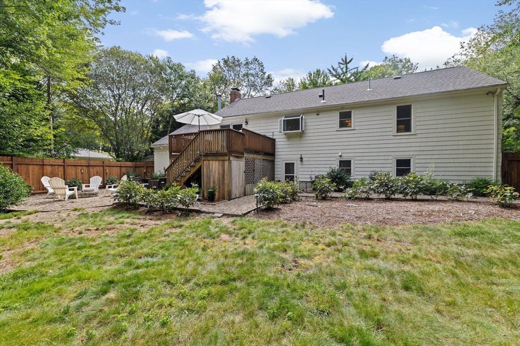 40 Brewster Road Cohasset, MA 02025 - Photo 41 of 42 a backyard of a house with table and chairs under an umbrella