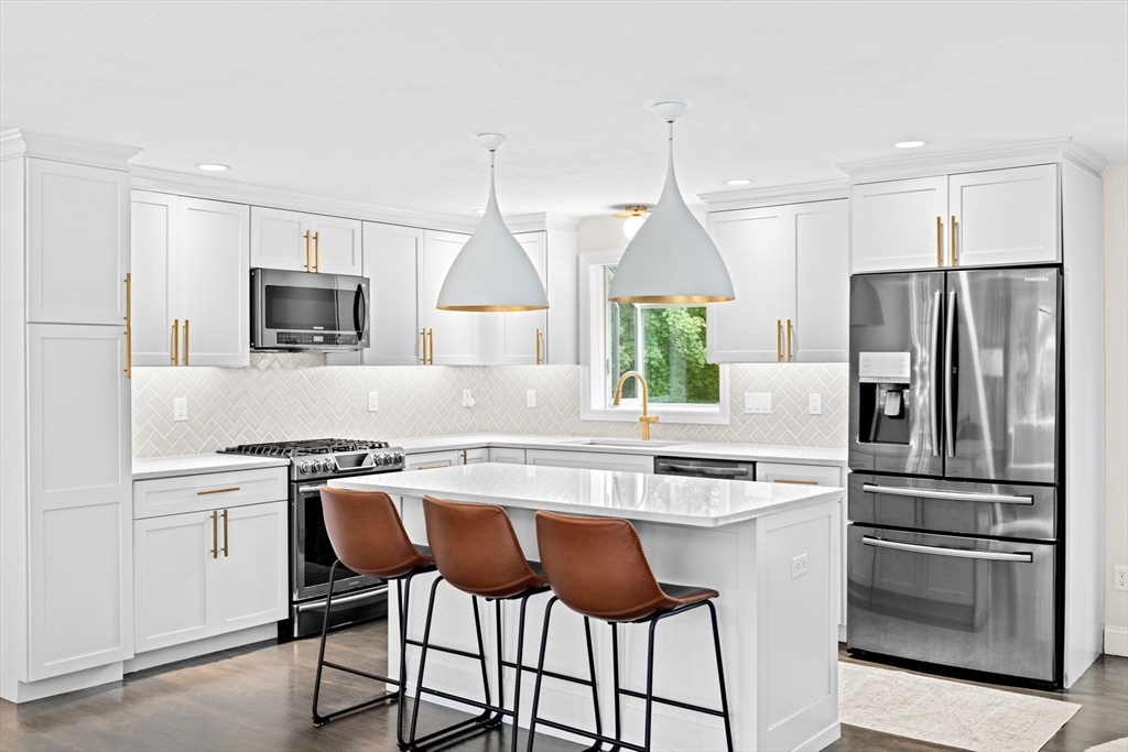 40 Brewster Road Cohasset, MA 02025 - Photo 5 of 42 a kitchen with kitchen island white cabinets and stainless steel appliances
