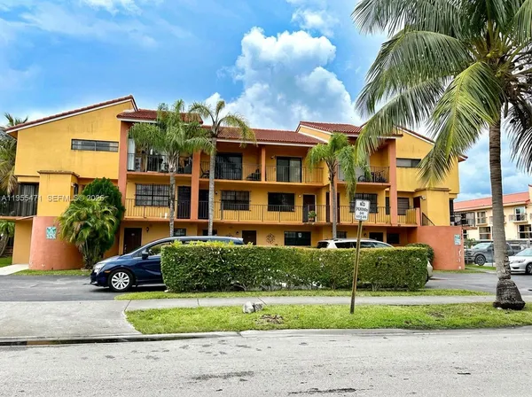 a front view of multiple houses with yard