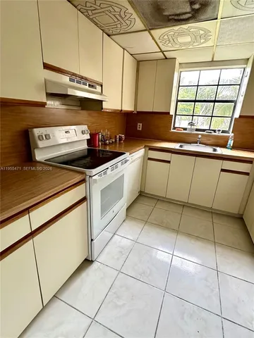 a kitchen with a stove a sink and cabinets