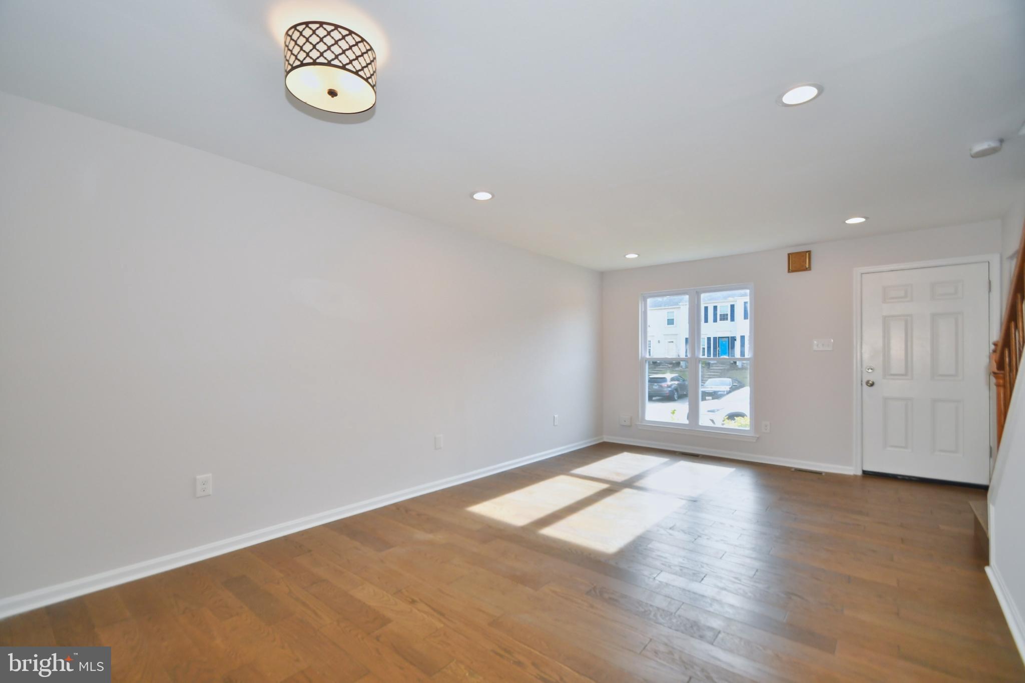 28 Pine Chip Court Baltimore, MD 21236 - Photo 13 of 32 a view of an empty room with a window and wooden floor