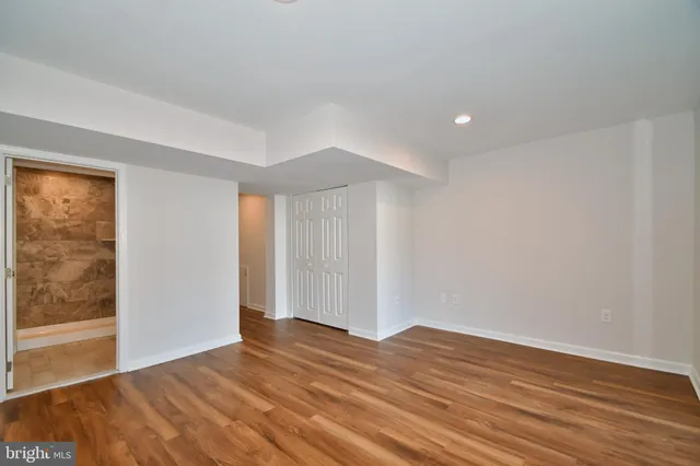 a view of empty room with wooden floor