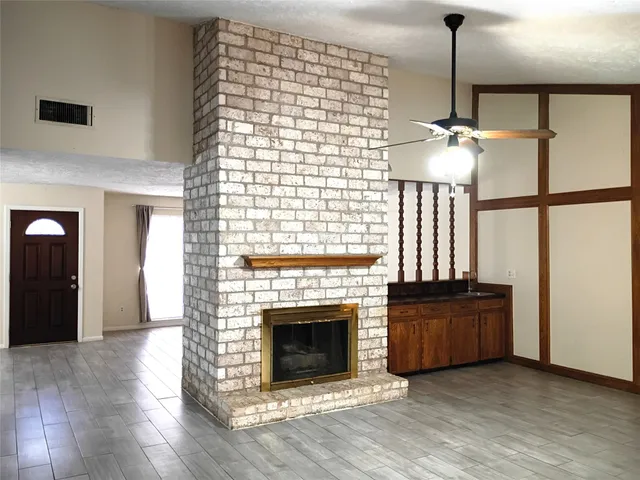 a view of empty room with wooden floor and fireplace