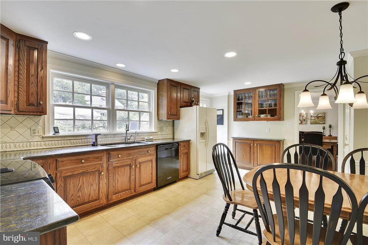 5 Cold Spring Court Potomac, MD 20854 - Photo 6 of 30 a kitchen with stainless steel appliances granite countertop a table chairs sink and window