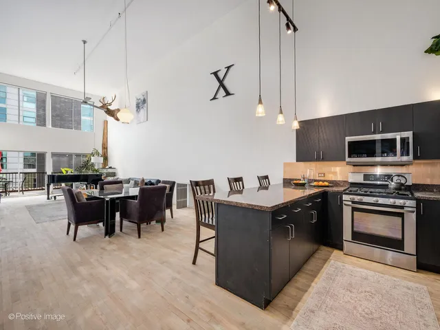 a kitchen with stainless steel appliances granite countertop a sink dishwasher stove top oven and cabinets with wooden floor