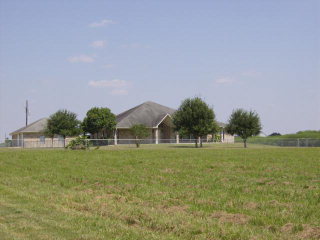 2225 Kohutek Road Victoria, TX 77904 - Photo 1 of 1 a backyard of a house with lots of green space and lake view in back