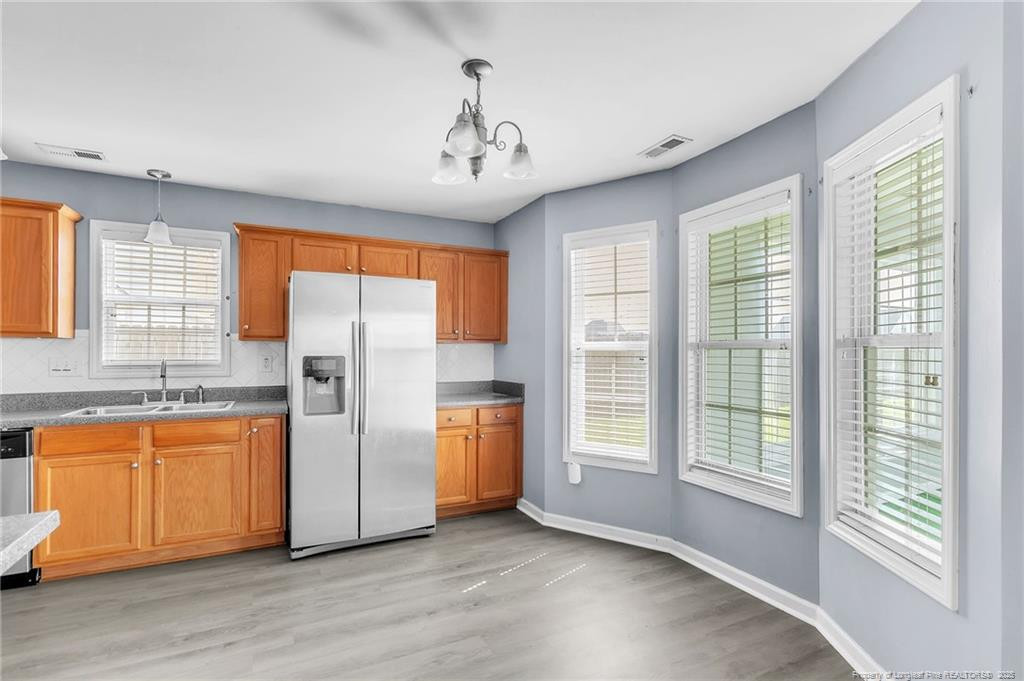 1948 Yellowbrick Road Fayetteville, NC 28314 - Photo 5 of 22 a view of a kitchen with stainless steel appliances granite countertop a refrigerator a sink and dishwasher with wooden floor