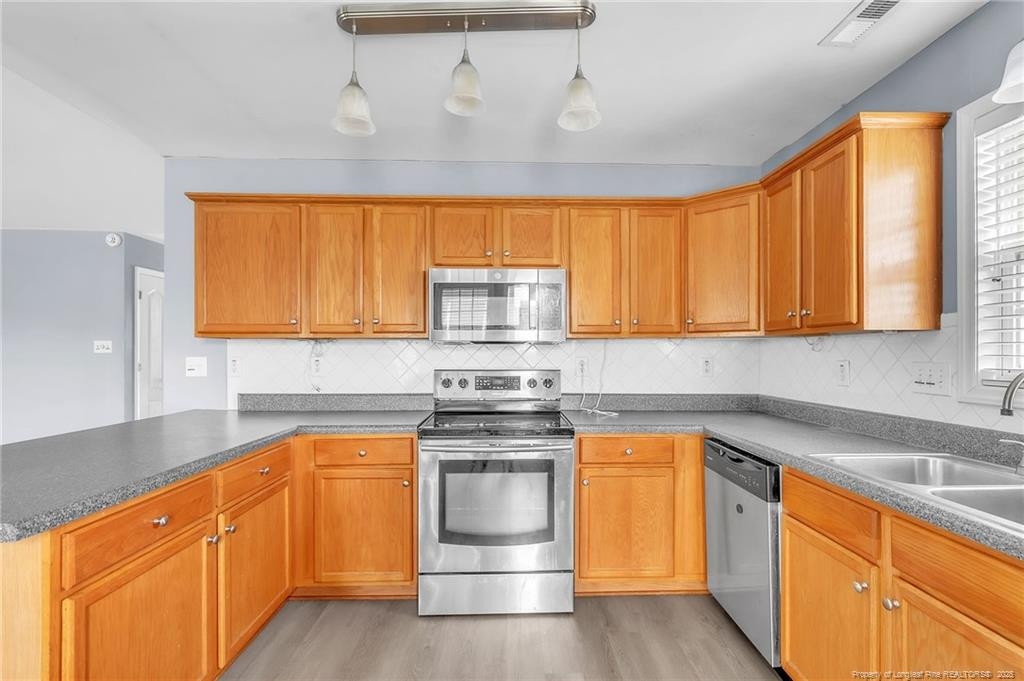 1948 Yellowbrick Road Fayetteville, NC 28314 - Photo 7 of 22 a kitchen with granite countertop white cabinets and stainless steel appliances