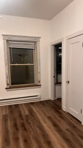 a view of a livingroom with wooden floor and cabinet