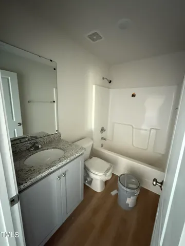 a bathroom with a granite countertop sink a toilet and a mirror