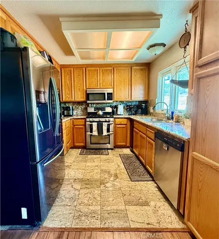 a kitchen with stainless steel appliances granite countertop sink stove top oven and cabinets
