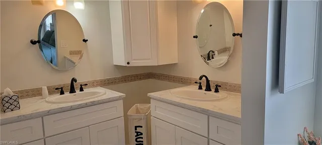a bathroom with double vanity sink and mirror