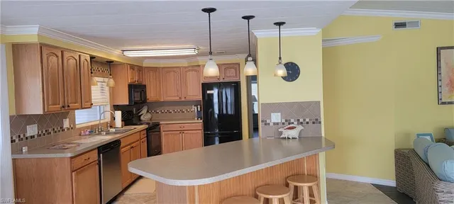 a kitchen with stainless steel appliances granite countertop a refrigerator a sink dishwasher and a stove with wooden floor