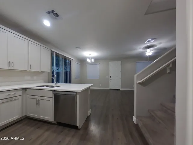 a kitchen with a sink cabinets stainless steel appliances and a window