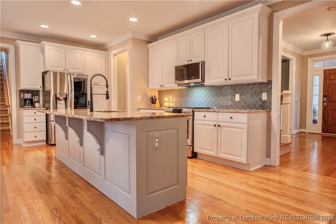 218 Waterville Street Raleigh, NC 27603 - Photo 14 of 49 a kitchen with stainless steel appliances granite countertop a stove a sink and a refrigerator