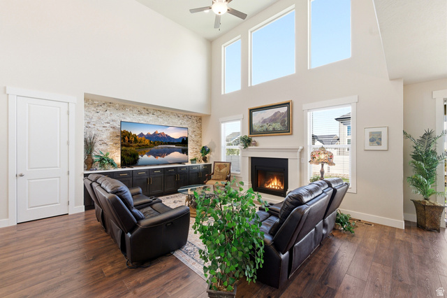 1434 West Stable Street Lindon, UT 84042 - Photo 8 of 76 Living area with a glass covered fireplace, dark wood finished floors, a high ceiling, and ceiling fan