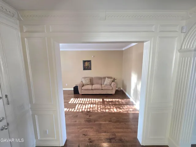 a kitchen with stainless steel appliances granite countertop a refrigerator a sink dishwasher a stove and white countertops with wooden floor