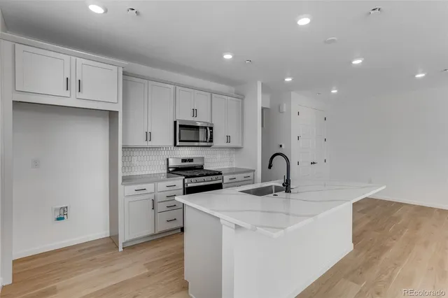 a kitchen with kitchen island a sink appliances and cabinets