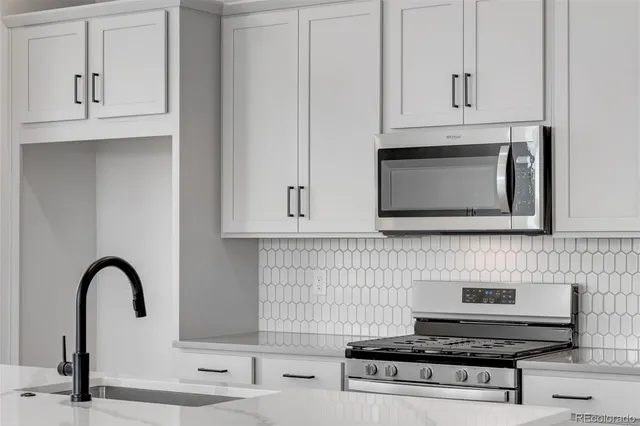 a kitchen with stainless steel appliances granite countertop a sink window and wooden floor