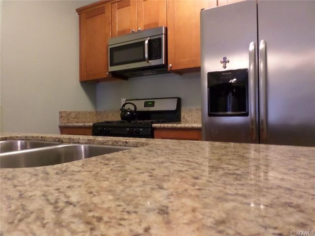 a kitchen with stainless steel appliances granite countertop a refrigerator and a microwave