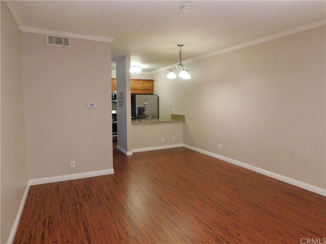 an empty room with wooden floor and mirror
