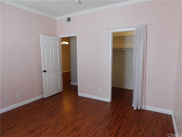 an empty room with wooden floor and closet