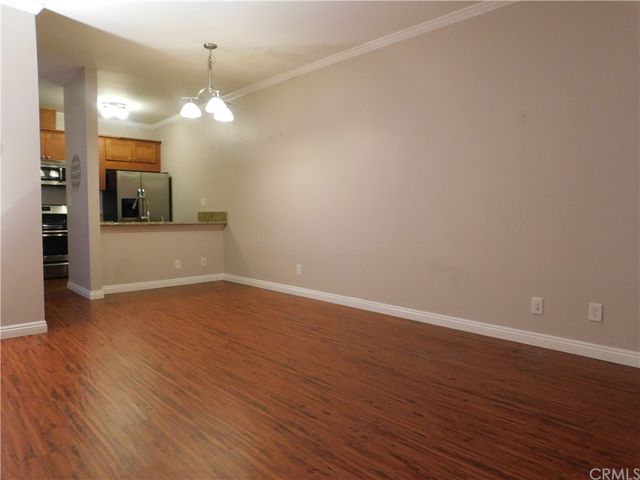 a view of a kitchen with wooden floor and a window