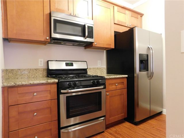 a kitchen with stainless steel appliances granite countertop a stove microwave and refrigerator