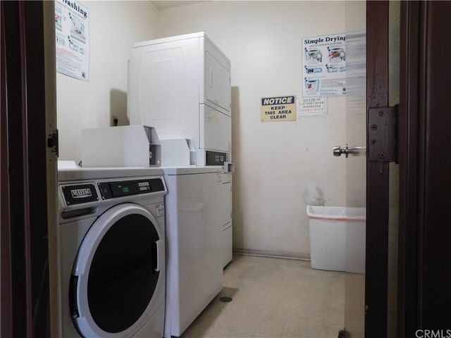 a view of an empty room with wooden floor and white doors