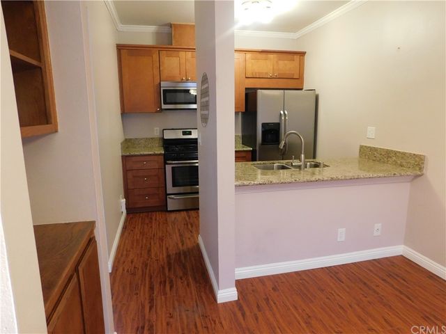 a view of kitchen with sink and refrigerator